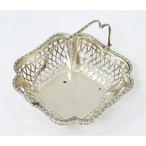 322 - A silver bon bon dish with pierced decoration and swing handle, hallmarked London 1913, maker John C... 