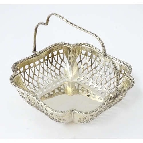 322 - A silver bon bon dish with pierced decoration and swing handle, hallmarked London 1913, maker John C... 