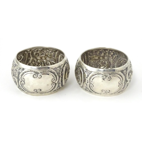 331 - A pair of Victorian silver napkin rings with embossed decoration, hallmarked Birmingham 1892, maker ... 