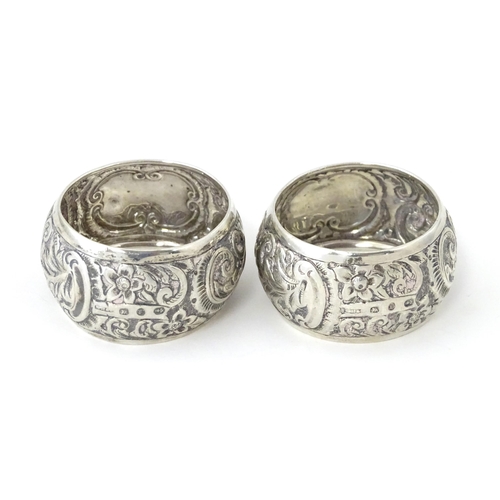 331 - A pair of Victorian silver napkin rings with embossed decoration, hallmarked Birmingham 1892, maker ... 