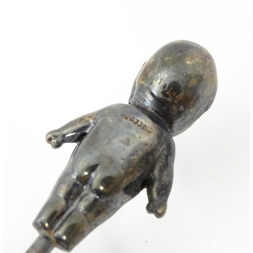 334 - A silver plate hat pin holder / ring tree surmounted by a model of a Kewpie doll. Marked with regist... 