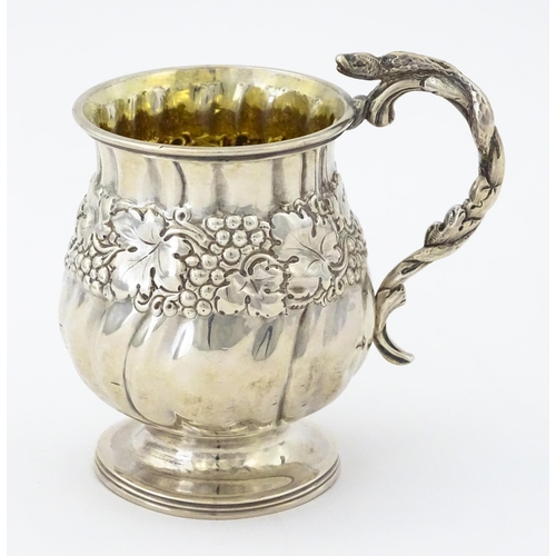 353 - A George III silver christening mug with embossed fruiting vine decoration, serpent formed handle an... 