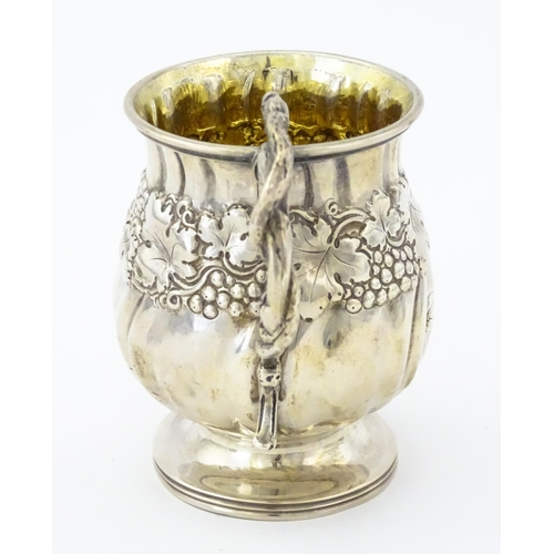 353 - A George III silver christening mug with embossed fruiting vine decoration, serpent formed handle an... 