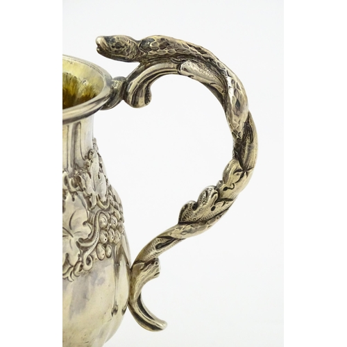 353 - A George III silver christening mug with embossed fruiting vine decoration, serpent formed handle an... 