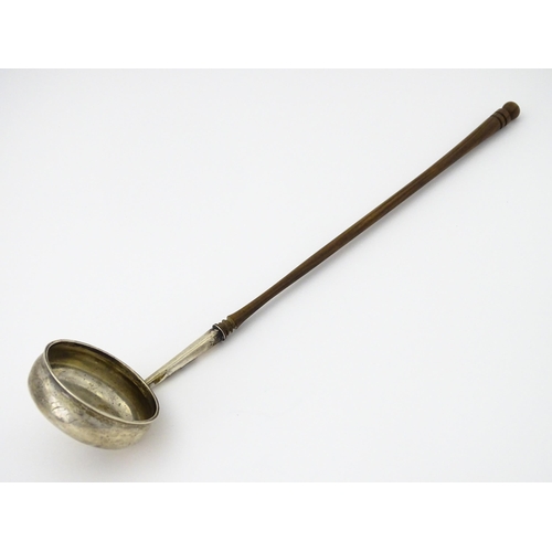 360 - A white metal toddy ladle with turned wooden handle, with inset 1816 coin style detail to centre. Ap... 