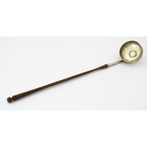 360 - A white metal toddy ladle with turned wooden handle, with inset 1816 coin style detail to centre. Ap... 