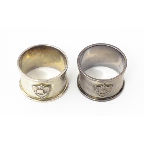 379 - A pair of Art Deco silver napkin rings with engine turned decoration and shield crest depicting boat... 