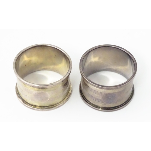 379 - A pair of Art Deco silver napkin rings with engine turned decoration and shield crest depicting boat... 