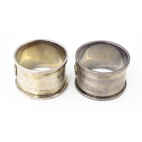 379 - A pair of Art Deco silver napkin rings with engine turned decoration and shield crest depicting boat... 