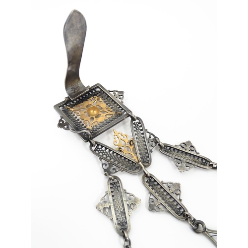 386 - A late 19th / early 20thC silver plate chatelaine with gilt metal highlights, having three hanging c... 