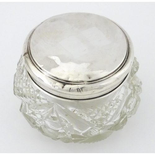 396 - A cut glass dressing table pot with silver lid hallmarked Birmingham 1923, maker Samuel M Levi. Appr... 