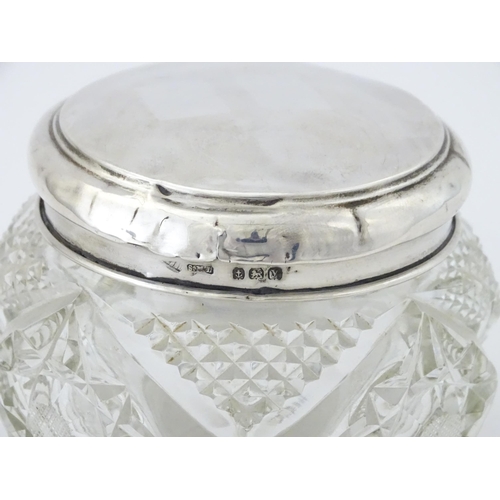 396 - A cut glass dressing table pot with silver lid hallmarked Birmingham 1923, maker Samuel M Levi. Appr... 