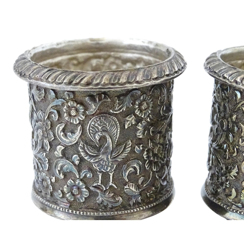 397 - A pair of white metal cruets / peppers of pedestal with floral and foliate decoration. Possibly Indi... 