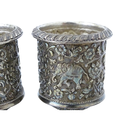 397 - A pair of white metal cruets / peppers of pedestal with floral and foliate decoration. Possibly Indi... 