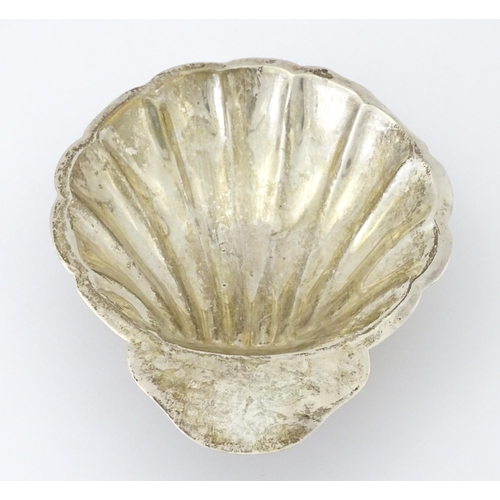 402 - A Mexican sterling silver butter dish of scallop shell form raised on three ball feet, by Juvento Lo... 