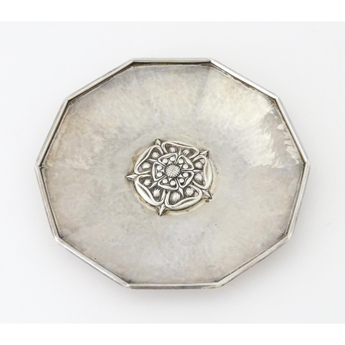 442 - An Arts & Crafts silver dish of decagon form with hammered decoration and centre Tudor rose motif, h... 