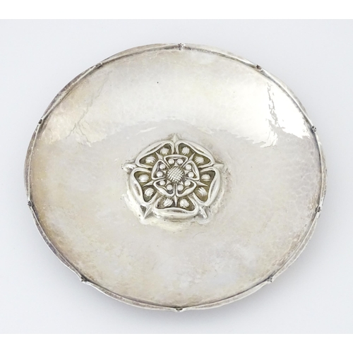 443 - An Arts & Crafts silver dish of circular form with hammered decoration and centre Tudor rose motif, ... 