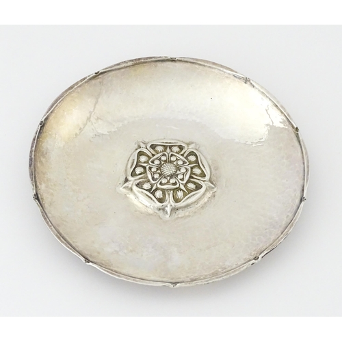 443 - An Arts & Crafts silver dish of circular form with hammered decoration and centre Tudor rose motif, ... 