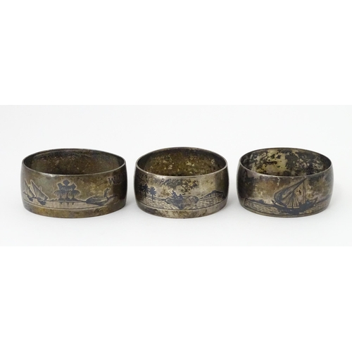 459 - Three white metal napkin rings with niello decoration depicting Egyptian scenes with camels, River N... 