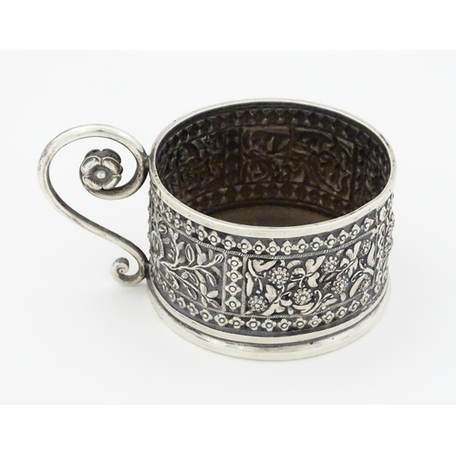 463 - An Oriental white metal tisane cup holder decorated with various panels depicting flowers, birds, cr... 