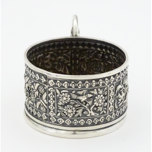 463 - An Oriental white metal tisane cup holder decorated with various panels depicting flowers, birds, cr... 