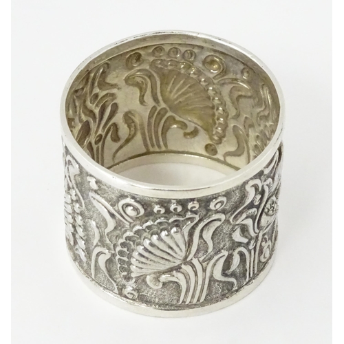 469 - A Continental white metal napkin ring  with floral and foliate detail, indistinctly marked to rim TO... 