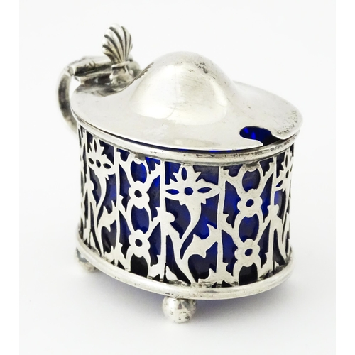 479 - A silver mustard pot of oval form with pierced decoration and blue glass liner, hallmarked Birmingha... 