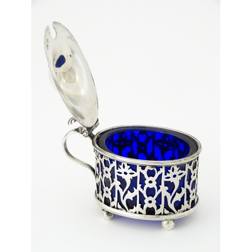 479 - A silver mustard pot of oval form with pierced decoration and blue glass liner, hallmarked Birmingha... 