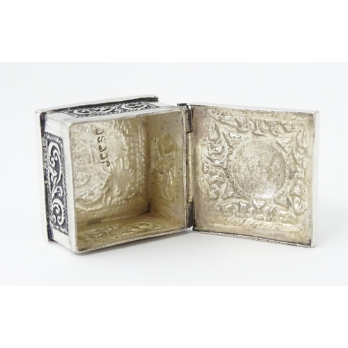 492 - A white metal pill box of squared form with scroll and elephant decoration. Indistinctly marked, pos... 