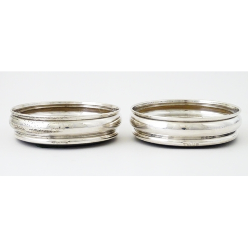 497 - A pair of silver bottle coasters with turned wooden bases, hallmarked London 1978, maker Da-Mar Silv... 