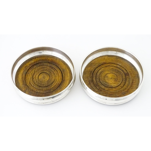 497 - A pair of silver bottle coasters with turned wooden bases, hallmarked London 1978, maker Da-Mar Silv... 