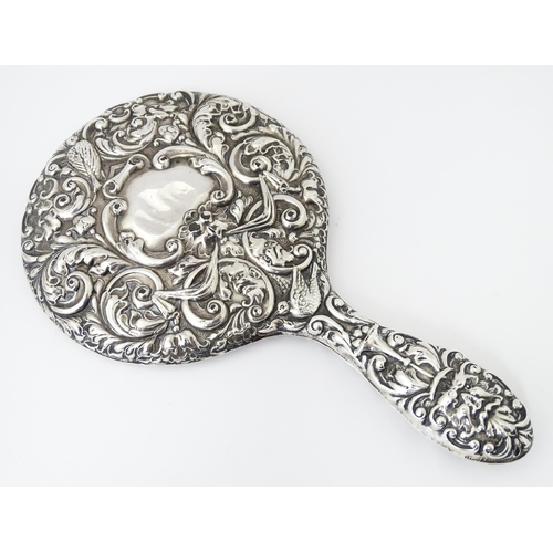 503 - A silver hand mirror with embossed decoration hallmarked Birmingham 1907, maker W. J Myatt & Co. App... 