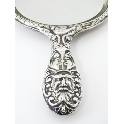 503 - A silver hand mirror with embossed decoration hallmarked Birmingham 1907, maker W. J Myatt & Co. App... 