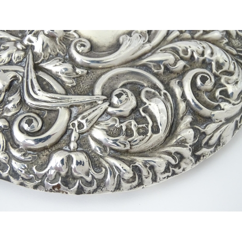 503 - A silver hand mirror with embossed decoration hallmarked Birmingham 1907, maker W. J Myatt & Co. App... 