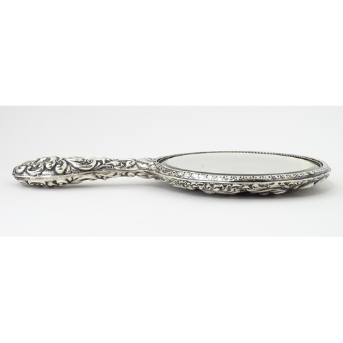 503 - A silver hand mirror with embossed decoration hallmarked Birmingham 1907, maker W. J Myatt & Co. App... 