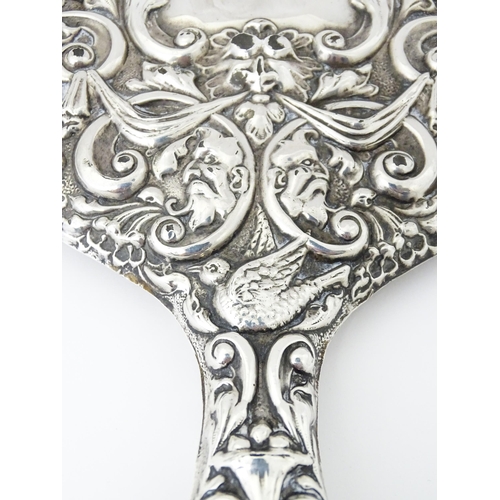 503 - A silver hand mirror with embossed decoration hallmarked Birmingham 1907, maker W. J Myatt & Co. App... 