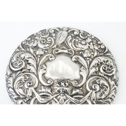 503 - A silver hand mirror with embossed decoration hallmarked Birmingham 1907, maker W. J Myatt & Co. App... 