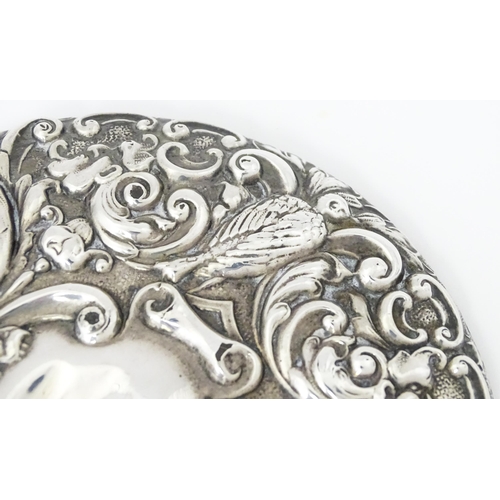 503 - A silver hand mirror with embossed decoration hallmarked Birmingham 1907, maker W. J Myatt & Co. App... 