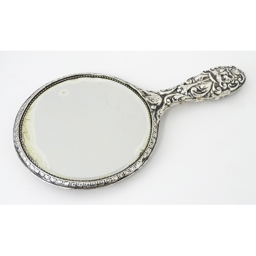 503 - A silver hand mirror with embossed decoration hallmarked Birmingham 1907, maker W. J Myatt & Co. App... 