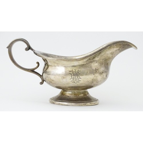 493 - A silver sauce boat hallmarked Sheffield 1912, maker Walker and Hall, and stamped under 1/2 Pint 518... 