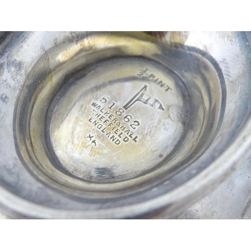 493 - A silver sauce boat hallmarked Sheffield 1912, maker Walker and Hall, and stamped under 1/2 Pint 518... 