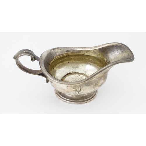 493 - A silver sauce boat hallmarked Sheffield 1912, maker Walker and Hall, and stamped under 1/2 Pint 518... 