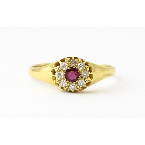 600 - An 18ct gold ring set with central ruby bordered by diamonds. Ring size approx. V 1/2