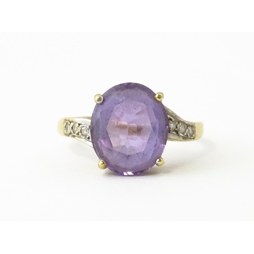 606 - A 9ct gold ring set with central amethyst flanked by diamonds. Ring size approx. O 1/2