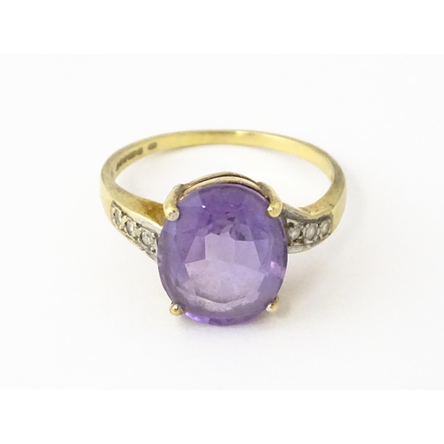 606 - A 9ct gold ring set with central amethyst flanked by diamonds. Ring size approx. O 1/2