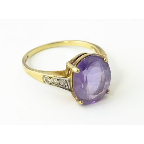 606 - A 9ct gold ring set with central amethyst flanked by diamonds. Ring size approx. O 1/2