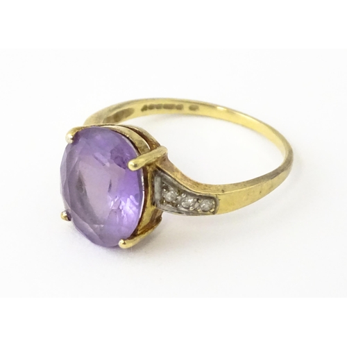 606 - A 9ct gold ring set with central amethyst flanked by diamonds. Ring size approx. O 1/2