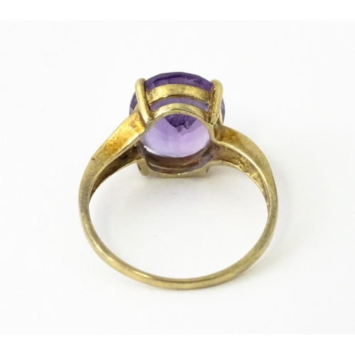 606 - A 9ct gold ring set with central amethyst flanked by diamonds. Ring size approx. O 1/2