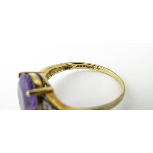 606 - A 9ct gold ring set with central amethyst flanked by diamonds. Ring size approx. O 1/2