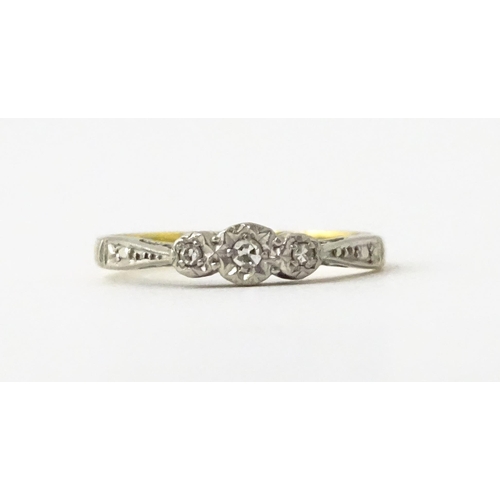 611 - An 18ct gold ring with three platinum set diamonds, maker Eaton & Wrighton. Ring size approx. K